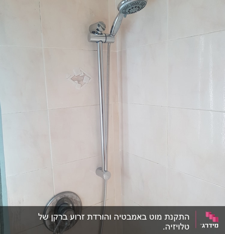 ראש מקלחת וכפתור מים על קיר אריחים